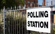 Polling station sign on a fence