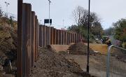 Construction of the retaining wall on Dame Dorothy Street to facilitate future road widening. Sheet piles are being pushed 13 metres into the ground to support the widened road.